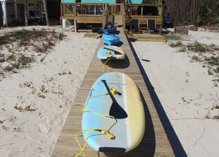 Two Kayaks and Two Standup Boards on the Boardwalk